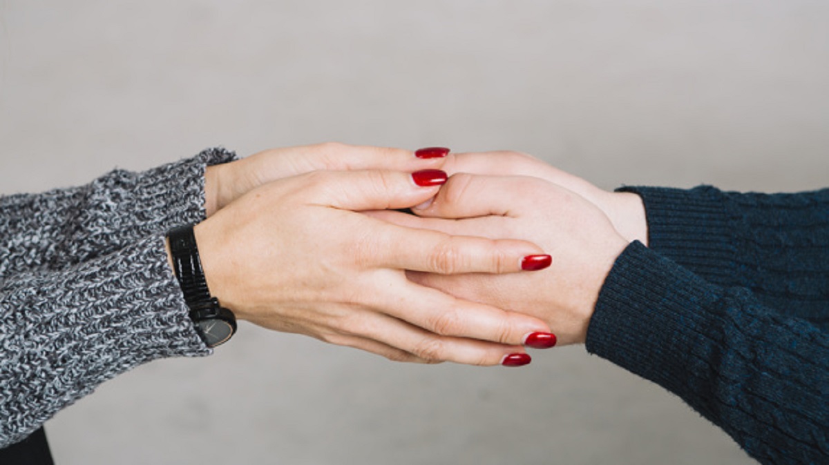 cropped-image-female-psychologist-holding-her-client-s-hands-against-gray-backdrop_23-2148036684