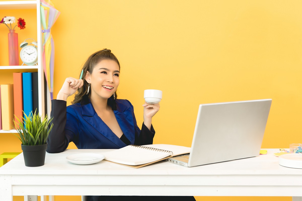 Cheerful business lady working on laptop in office